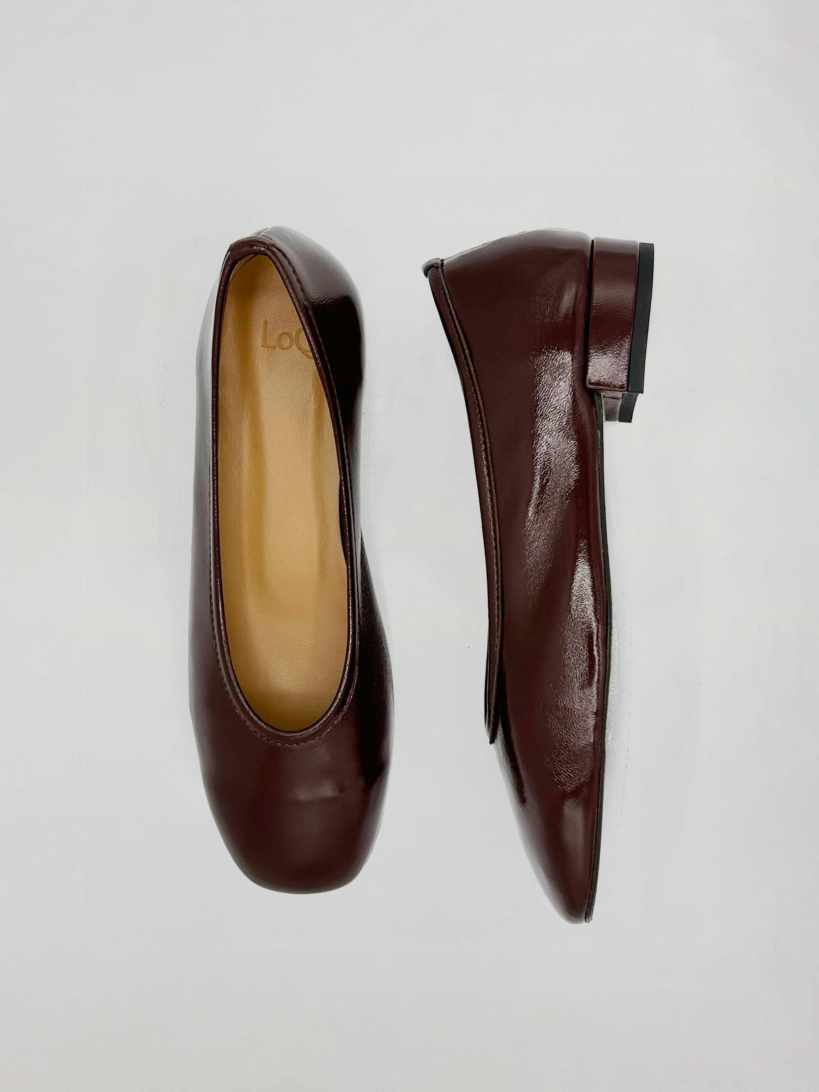 A pair of dark burgundy leather ballet flats shown from top and side views on a light gray background.