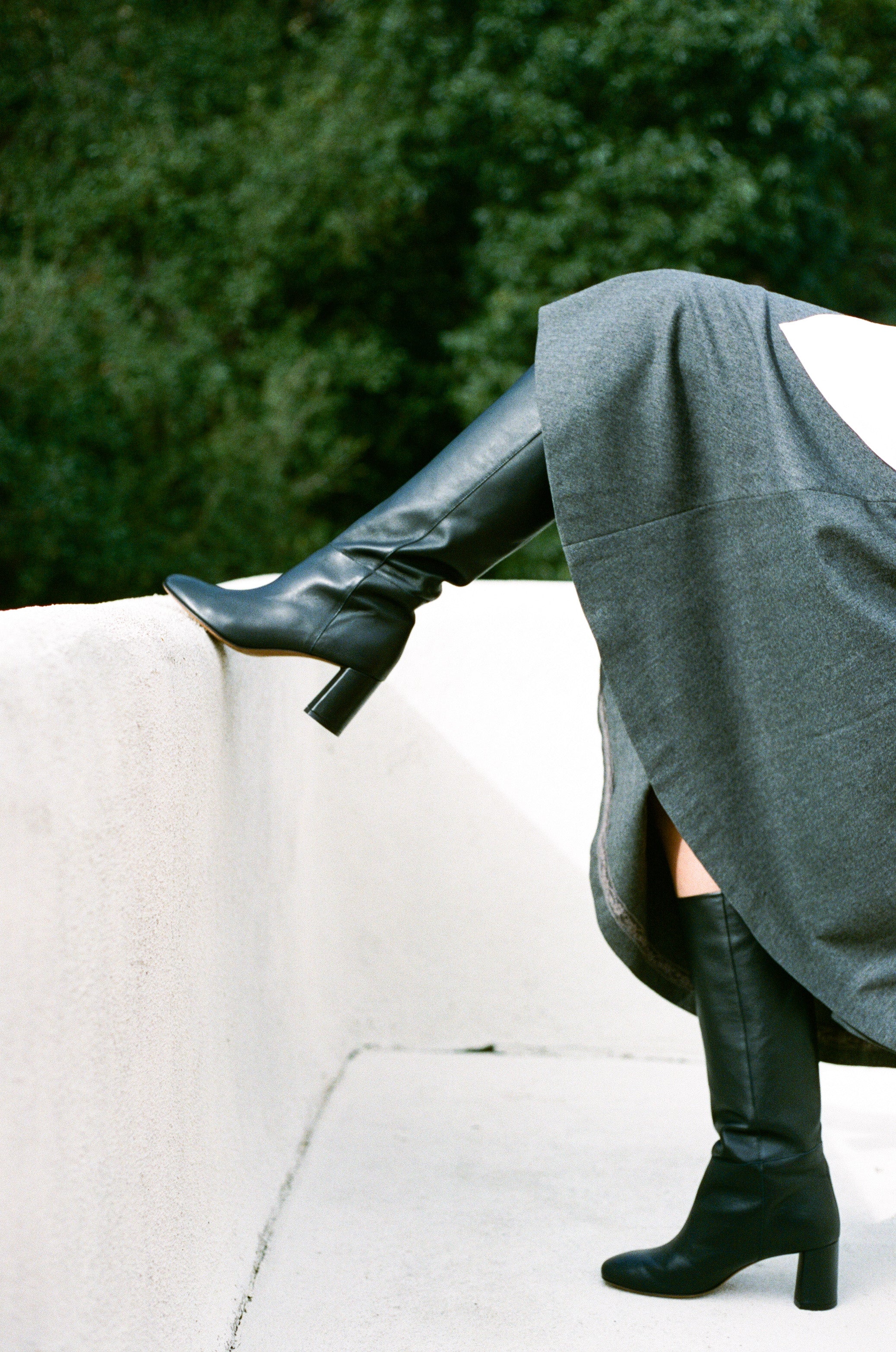 Model wears tall pull-on boot in a supple classic black leather that sits below the knee with a round toe