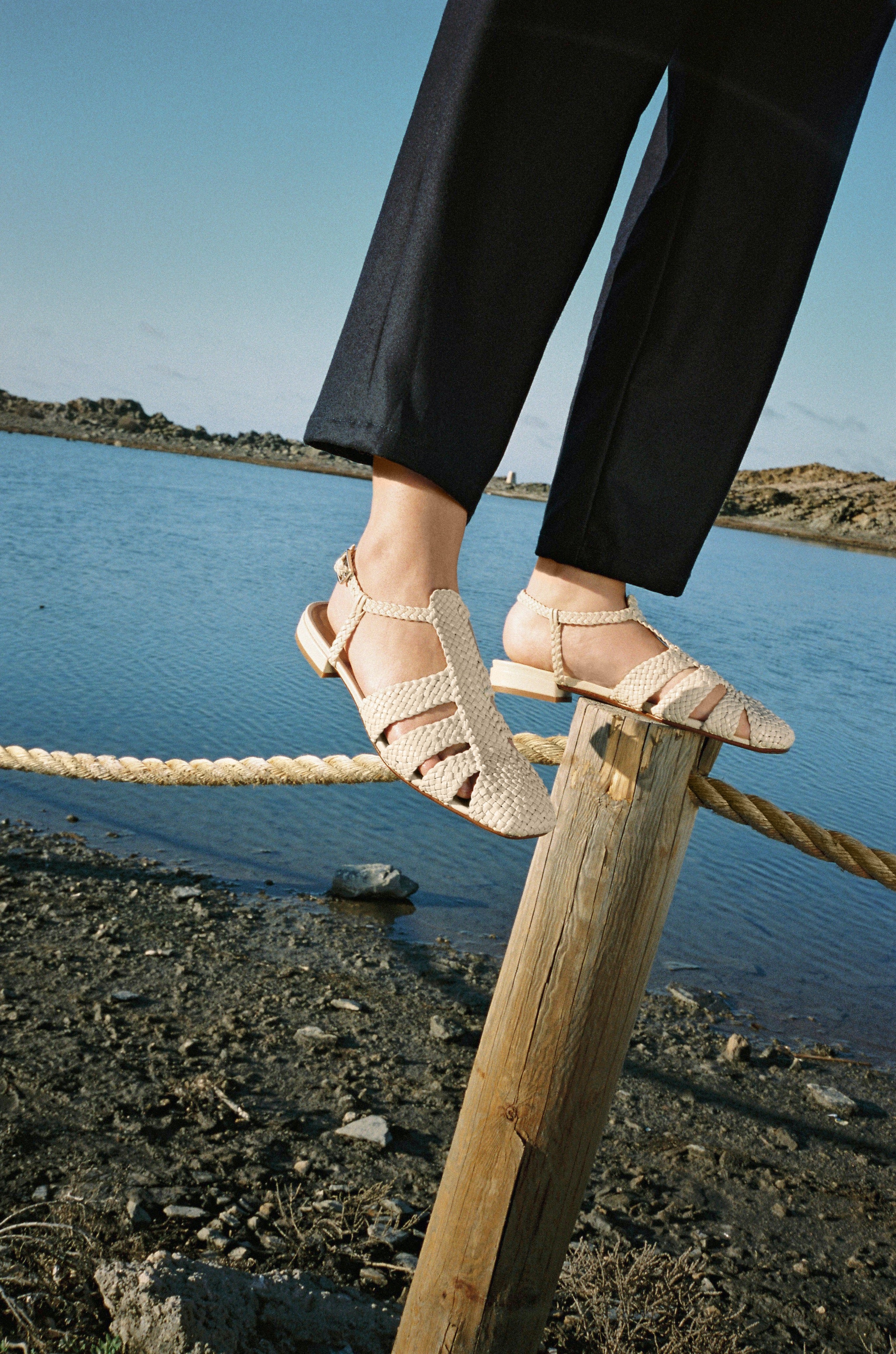 Fisherman-style sandals featuring straps made of woven leather across the foot and a strap that buckles around the ankle