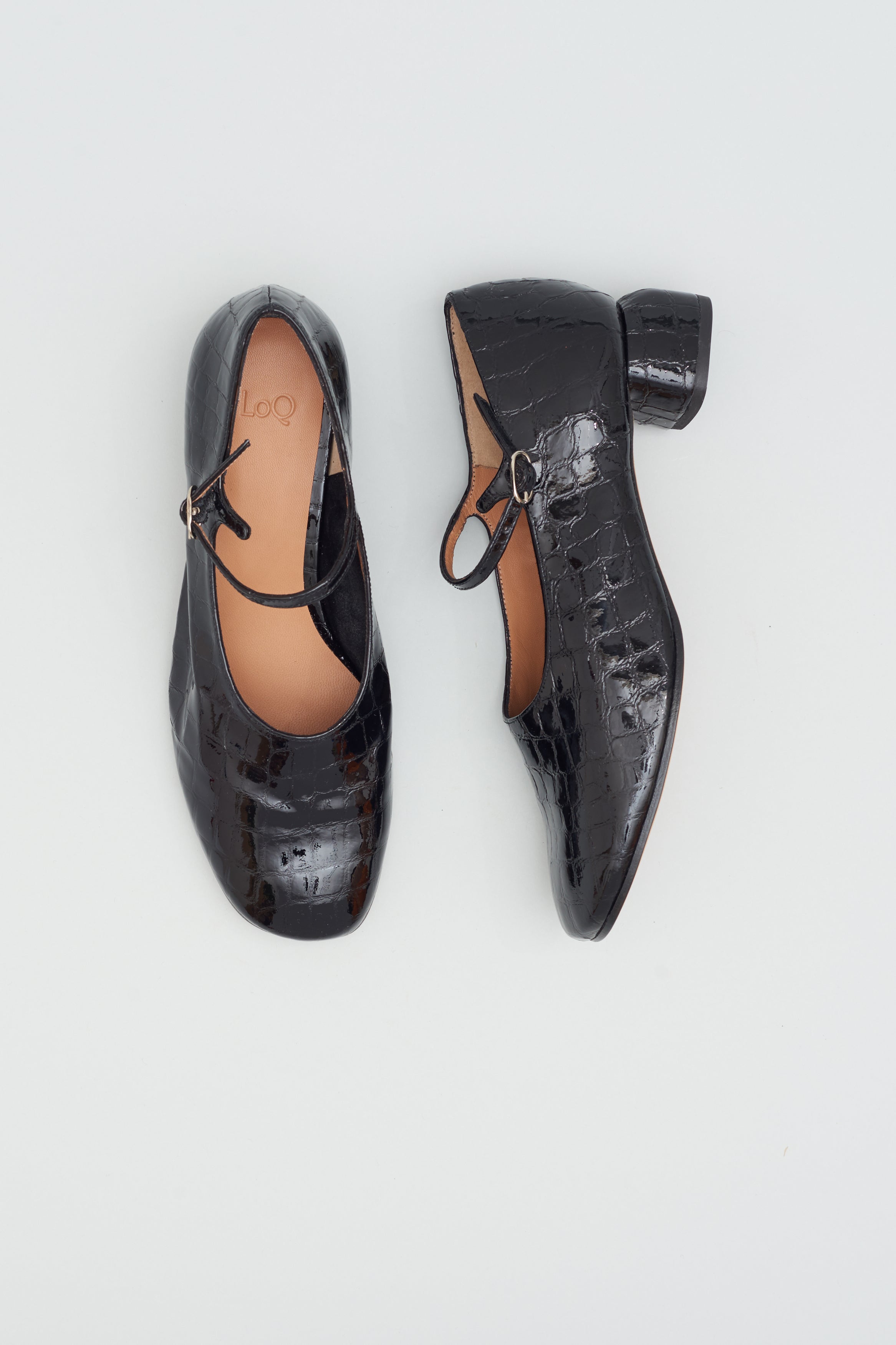 Modern Mary Jane featuring a classic silver buckle with an updated round heel in black patent embossed crocodile-motif leather. Round toe and 1" covered heel.