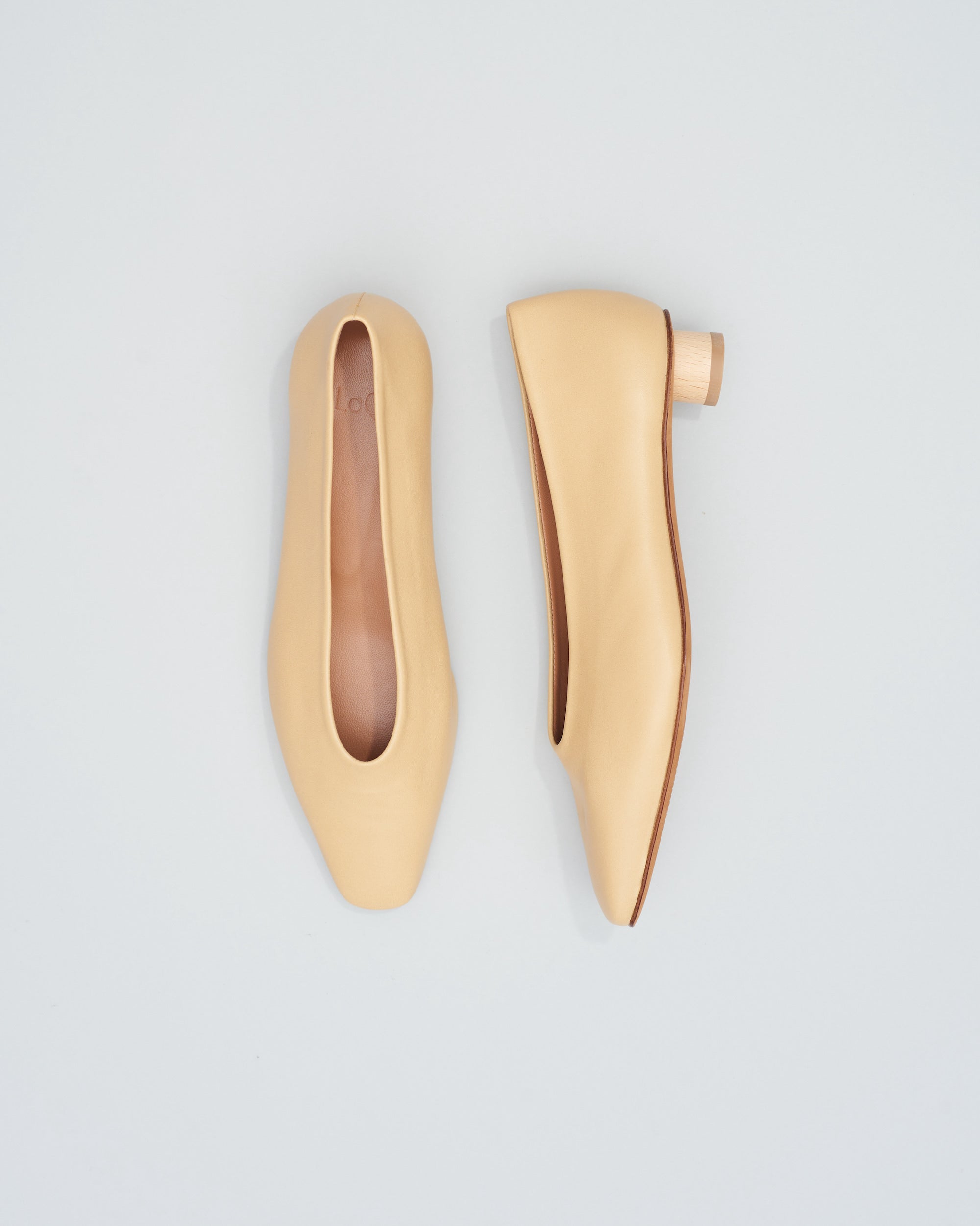 Ballet flat with a squared-off almond toe in a supple unlined beige leather for glove-like fit. Mini ¾ inch cylinder beechwood heel.
