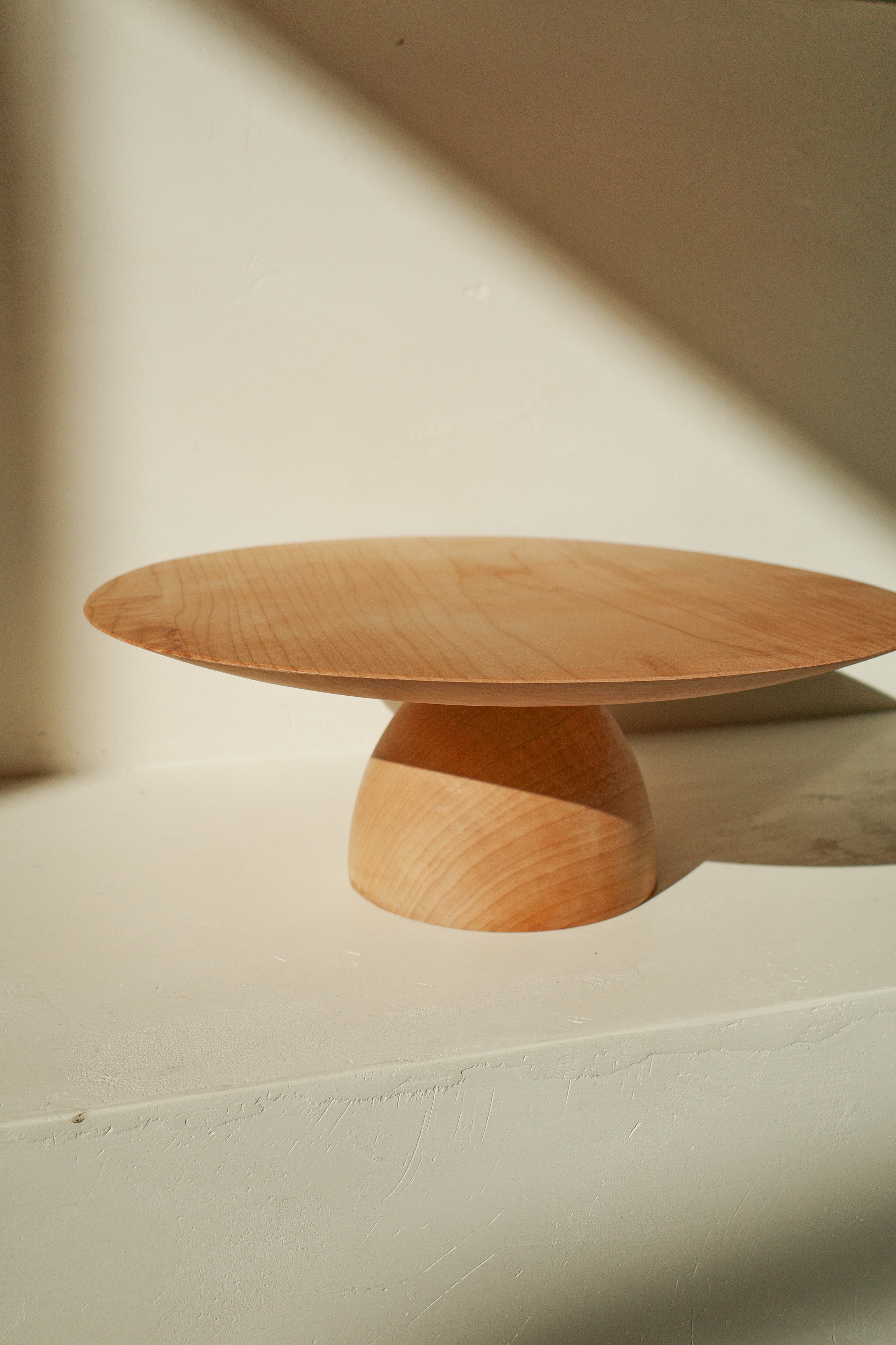 Hand turned wood cake stand with dome shaped base.