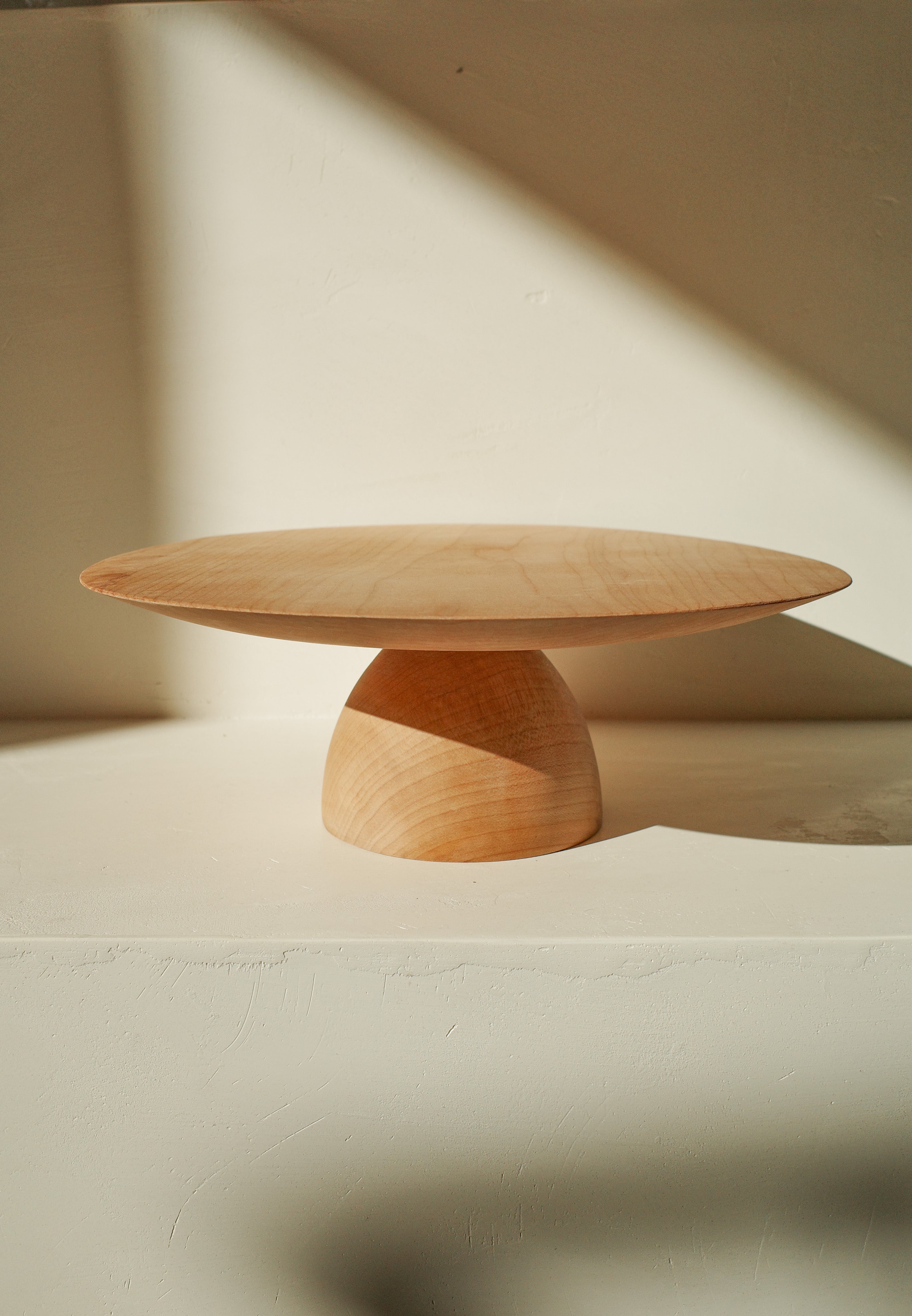 Hand turned wood cake stand with dome shaped base.