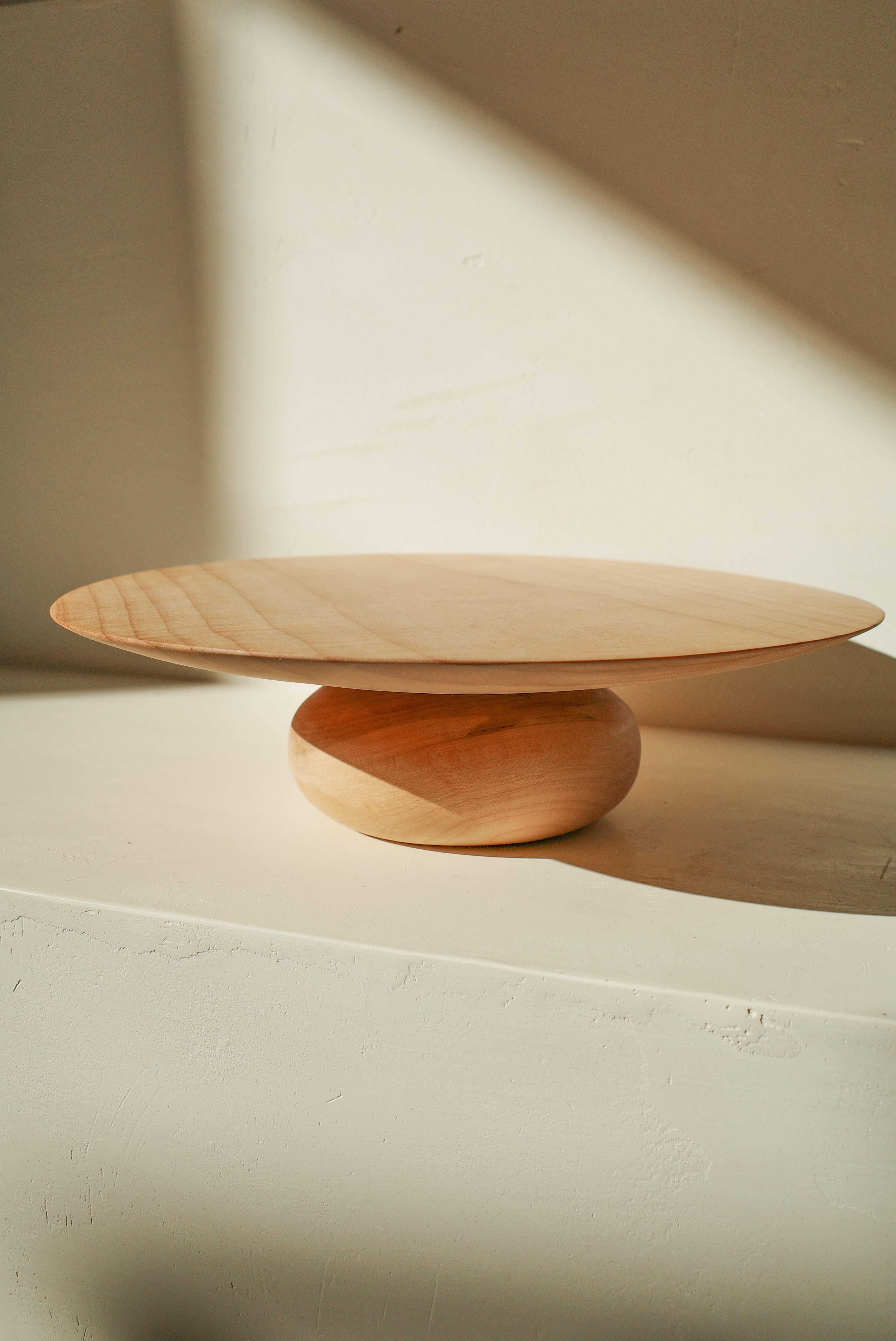 Hand turned wood cake stand with rounded donut shaped base.