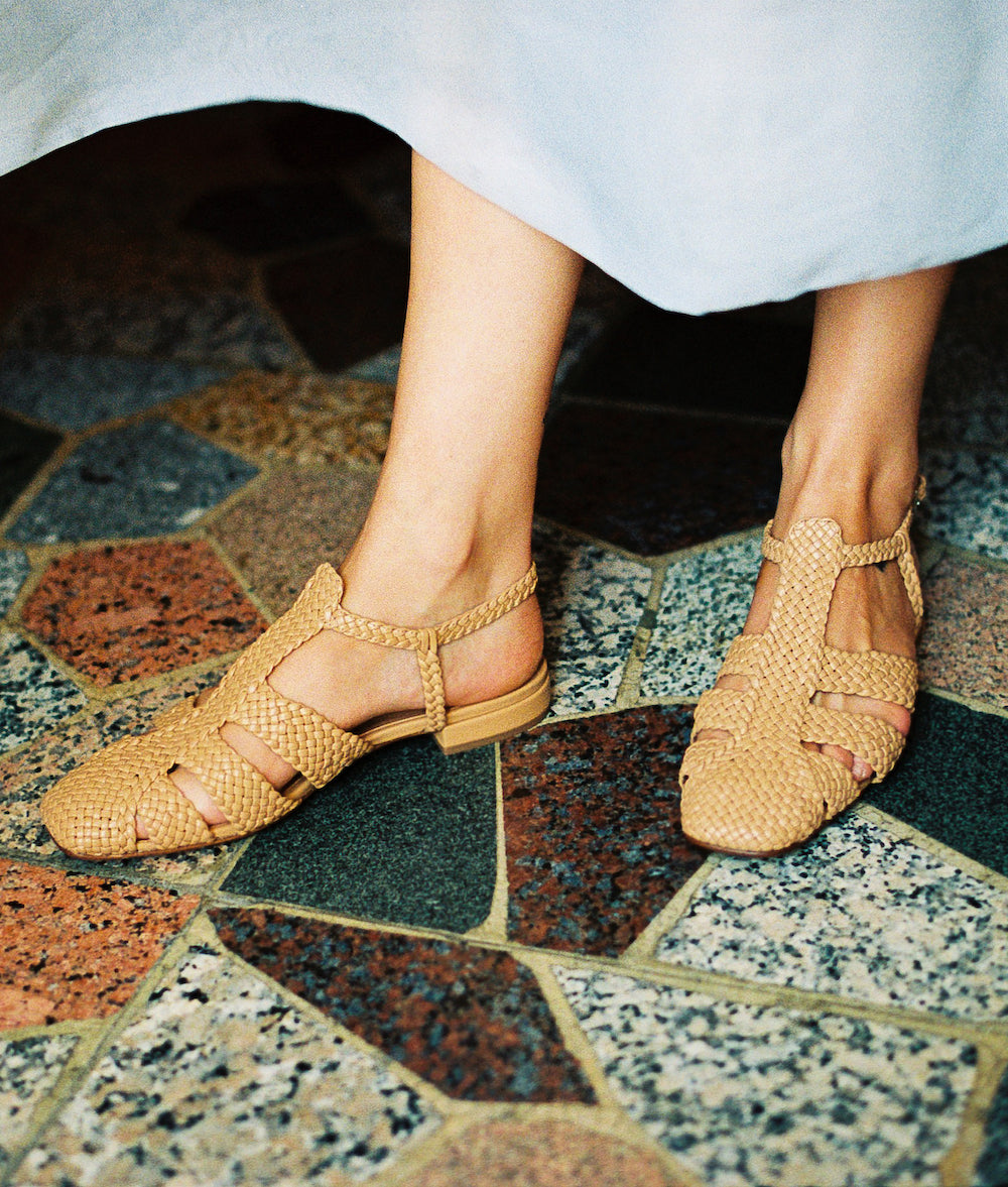 Carmel tan leather fisherman-style sandals featuring straps made of woven leather across the foot and a strap that buckles around the ankle