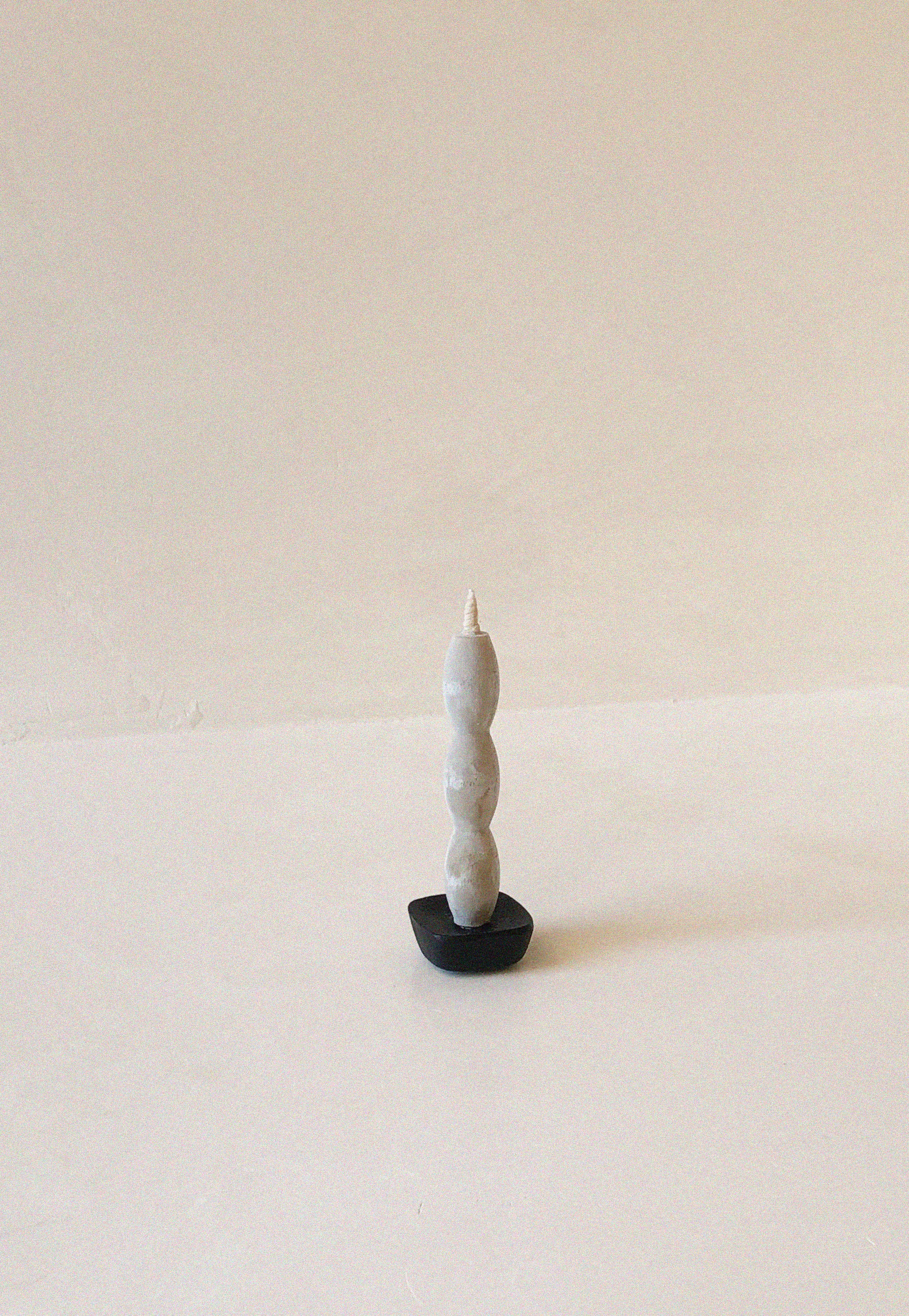 Set of five off-white candles, each one with a different wavy silhouette.