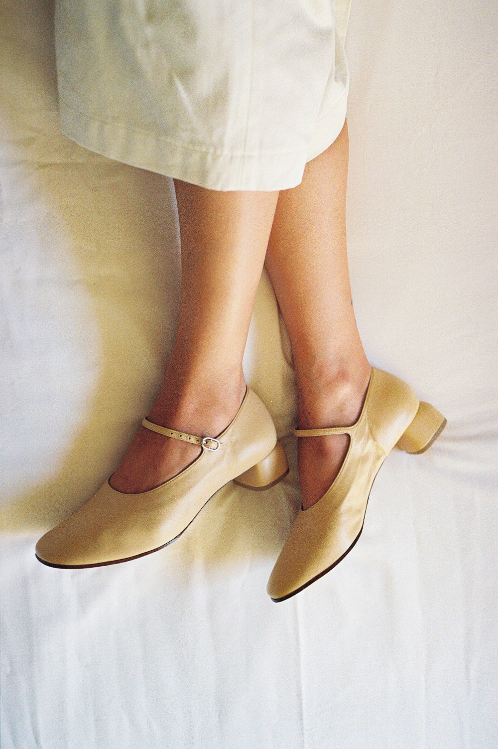 Modern Mary Jane featuring a classic silver buckle with an updated round heel in biscuit beige leather. Round toe and 1" covered heel.